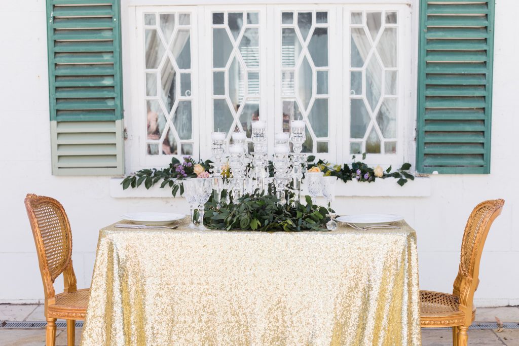 table setting outside with crystal glasses and leaves as the centerpiece