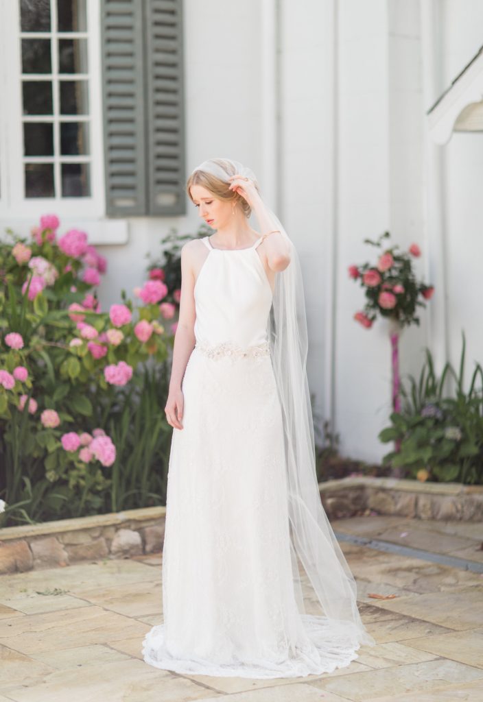 the bride wears a simply elegant white dress with a crystal detailed belt