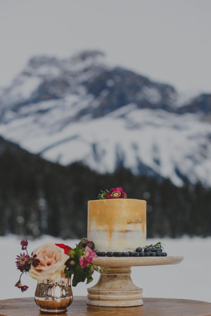 Single tiered wedding cake covered in white buttercream icing with a cold gradient from the top of the cake to 3/4th of the way down