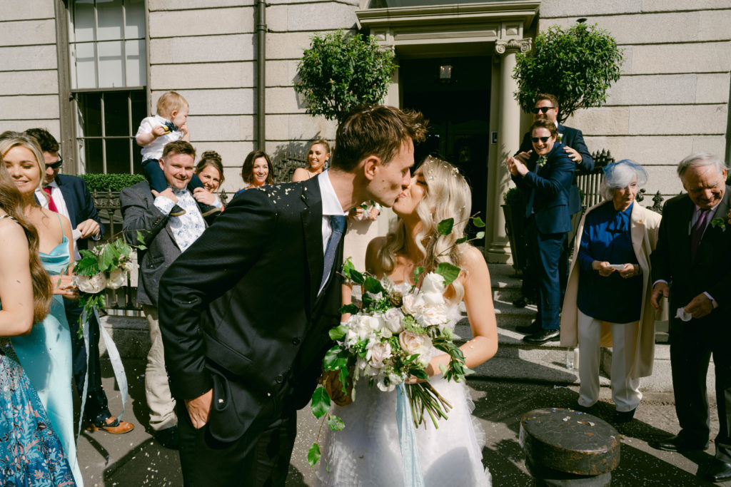 Irish bride and groom kissing outside of wedding venue in Dublin, Ireland