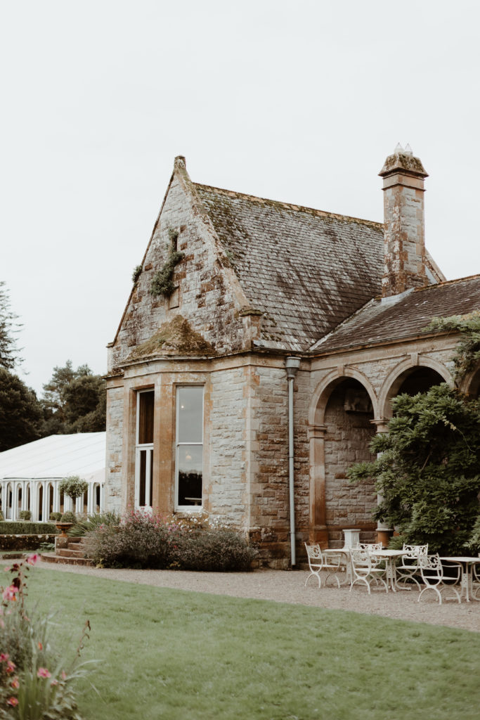 Grey stone building next to a large white marquee in Castle Leslie estate in Ireland